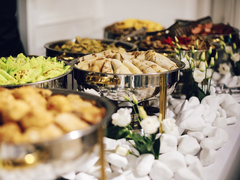 Silver chafing dishes lined up along a buffet table