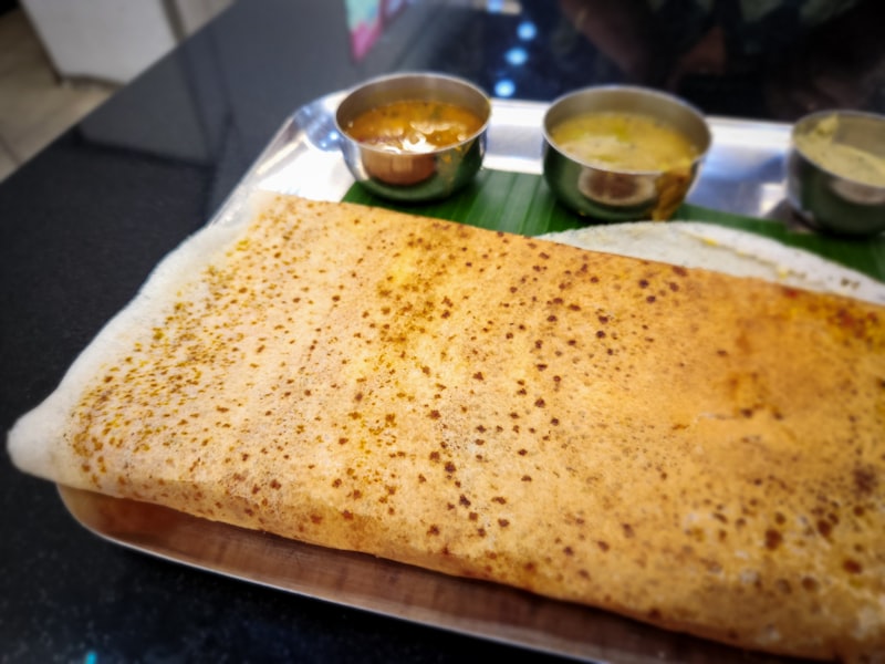 Crisp dosa plated with three accompanying chutneys