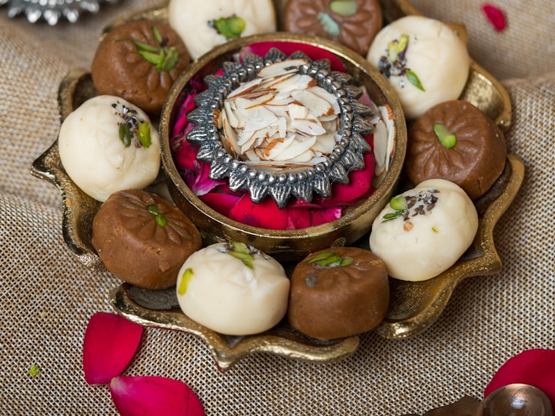 Assorted Indian sweets arranged on a plate at a dessert counter