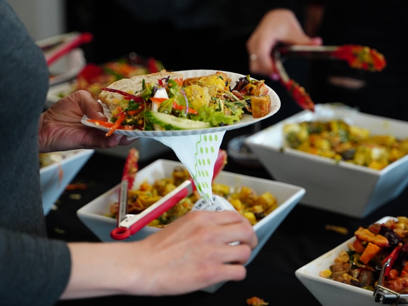 Server holding a bowl of vegetarian food during buffet service