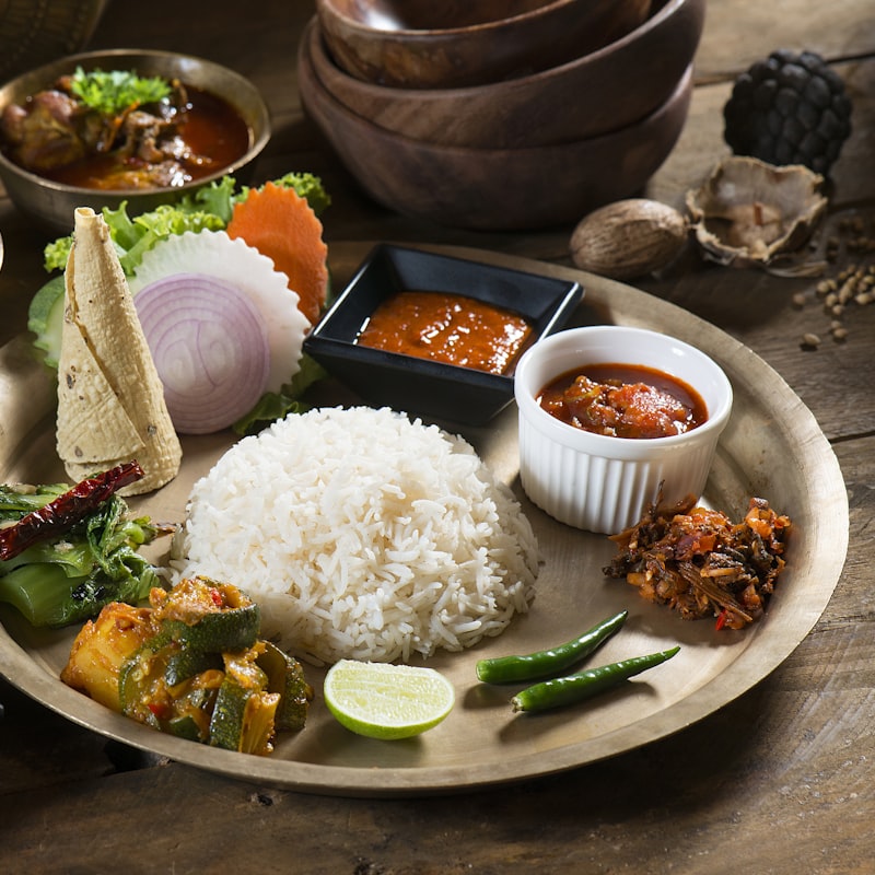Close-up of steamed rice with vegetable curries on a plate